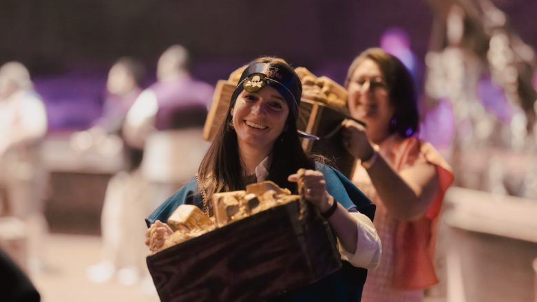 A smiling guest carries a treasure chest of gold during the show
