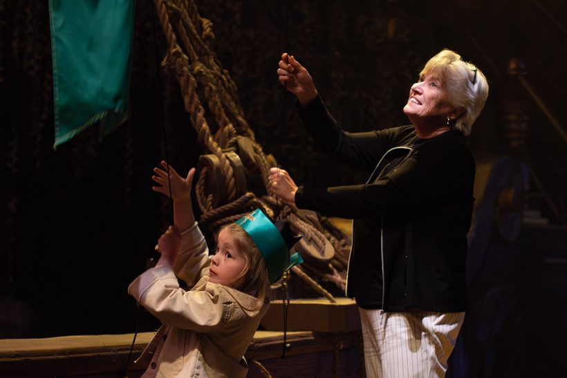 A grandmother and granddaughter raise a sail together during the show